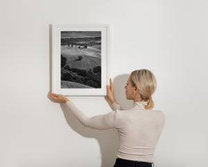 Monochrome toskanische Landschaft mit einsamen Bäumen und einer kleinen Kapelle auf einem Hügel.