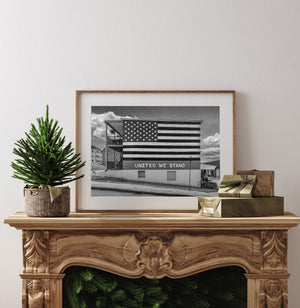 Black and white street photograph of a weathered American flag mural.