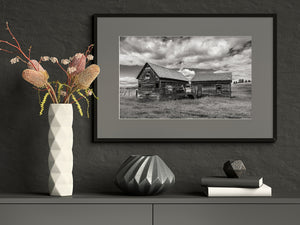 Abandoned farm structures and old machinery in an open field