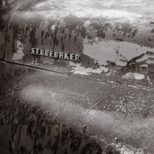 Close-up of a Studebaker emblem on an aged truck panel