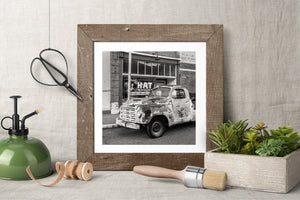 Bisbee street scene with a weathered truck beneath a hat shop window