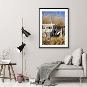 Weathered school bus with rust marks and number 108 among golden reeds