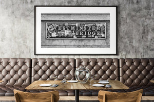 Panoramic black and white photograph of a London sign covered with stickers