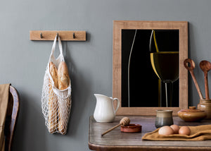 Dark still life photograph of wine glass curves and bottle reflections