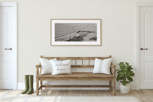 Black and white view of marsh grasses and a winding boardwalk