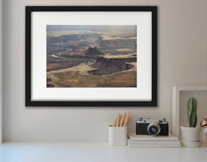 Layered desert cliffs and river bends viewed from high above