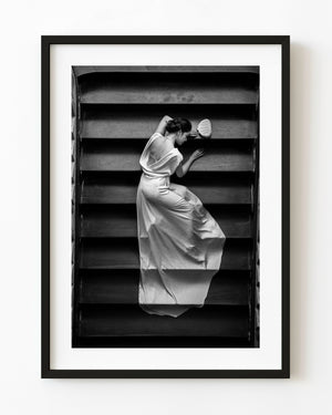 Woman in a white gown on a Saigon staircase in black and white