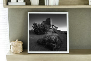 Stone walls and weathered rock above desert shrubs at Wukoki Pueblo
