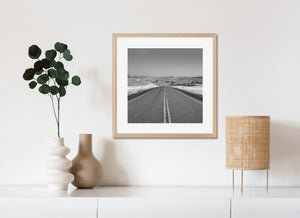 Black and white Wyoming landscape with a winding road and dry grass