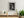 Black and white still life of household vessels against a textured wall in a Japanese samurai residence.