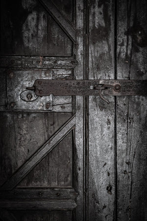 Iron locking hardware crossing aged wooden panels with visible grain and worn edges.