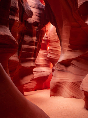 Gewundene Passage im Antelope Canyon zwischen hohen Wänden aus rotem Sandstein in der Wüste von Arizona.