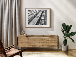 Monochrome overhead railway photograph showing rows of trains beside exposed tracks.