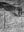 Weathered fence posts lead toward a sandstone wall marked with rock art at Canyon de Chelly.