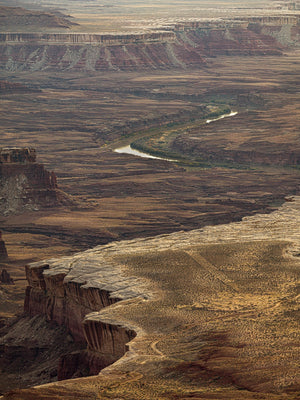 Acantilados de cañón en terrazas rodean un río angosto muy por debajo de un escarpado mirador del desierto.