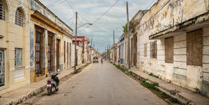 Vrouw fietst door de straat in Cuba | Foto Kunstprint Fine Art fotografische afdruk