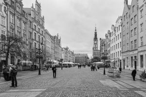 Historische Giebelfassaden säumen beide Seiten der breiten Fußgängerzone von Danzig in Schwarzweiß.