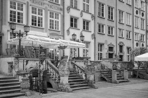 Gemeißelte Steinbalustraden und Eisengeländer führen zu Geschäften in einer historischen Danziger Straße
