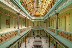 Architekturfoto in Farbe der Buntglasdecke des Hotel Raquel über symmetrischen grünen Galerien.