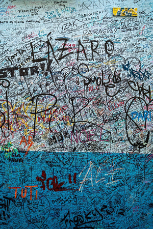 Fotografía en color de firmas manuscritas sobre yeso azul en La Bodeguita.