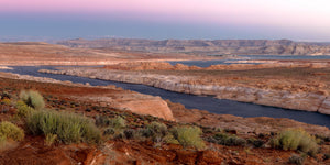 Canales azules del lago Powell serpentean entre orillas de arenisca roja y clara al amanecer