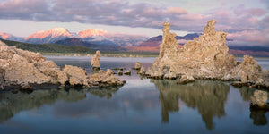 Formaciones de piedra caliza pálida se reflejan en las tranquilas aguas azules del Lago Mono