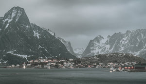 Küstendorf Reine unter steilen, schneebedeckten Gipfeln in Norwegen