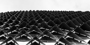 Repeating triangular sunshades rising toward a pale sky at SAHMRI
