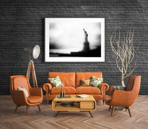 Black and white Statue of Liberty against a broad textured sky.