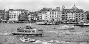 Passagierboote und Motorboote hinterlassen Spuren entlang einer venezianischen Uferpromenade
