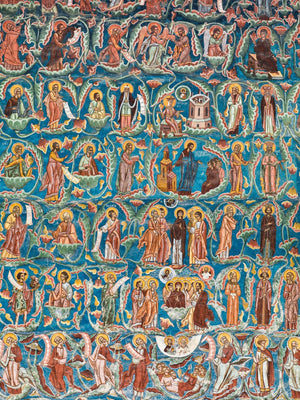 Colourful saints and winding green motifs on a blue Romanian monastery wall.