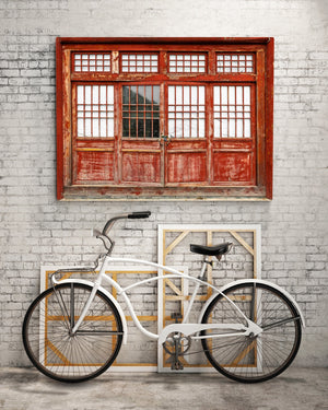 Worn red paint and geometric window grids on a Chinese wooden doorway