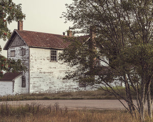 Casa antigua de Ontario con revestimiento blanco desconchado y techo marrón rojizo