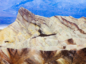 Colour landscape of pale desert folds and a pointed ridge at Zabriskie Point